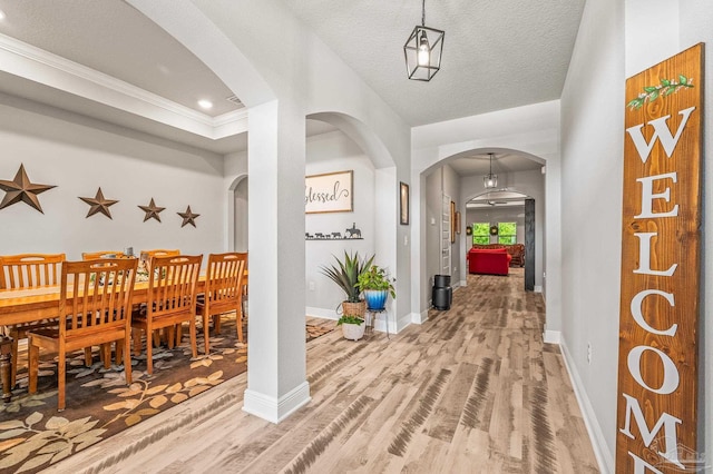 8056 Stream Ridge Rd, Pensacola, FL 32526 - hallway with arched walkways, light wood-style flooring, baseboards, and ornamental molding
