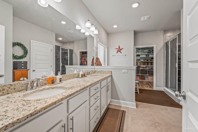 8056 Stream Ridge Rd, Pensacola, FL 32526 - full bathroom featuring a walk in closet, a stall shower, double vanity, baseboards, and recessed lighting