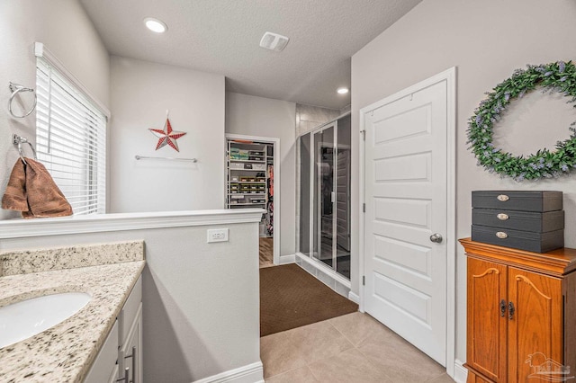 8056 Stream Ridge Rd, Pensacola, FL 32526 - bathroom with a stall shower, vanity, tile patterned floors, a textured ceiling, and a spacious closet