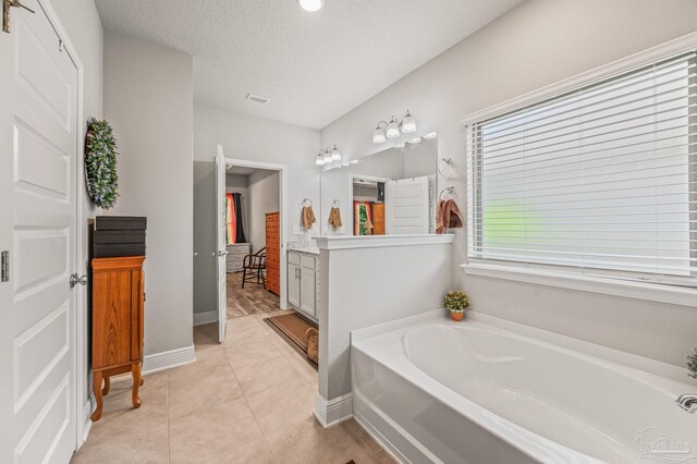 8056 Stream Ridge Rd, Pensacola, FL 32526 - full bathroom featuring vanity, a garden tub, baseboards, a textured ceiling, and tile patterned floors