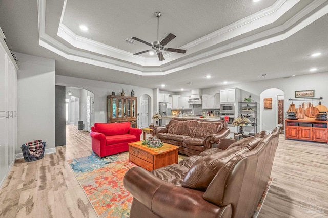 8056 Stream Ridge Rd, Pensacola, FL 32526 - living area featuring arched walkways, a ceiling fan, a raised ceiling, ornamental molding, and light wood-type flooring