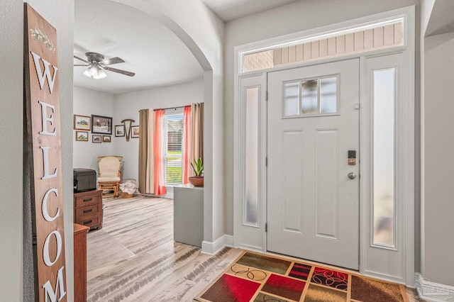 8056 Stream Ridge Rd, Pensacola, FL 32526 - foyer entrance with arched walkways, light wood finished floors, a ceiling fan, and baseboards