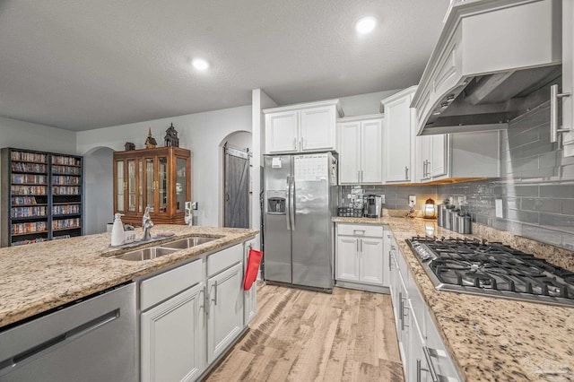 8056 Stream Ridge Rd, Pensacola, FL 32526 - kitchen with appliances with stainless steel finishes, a sink, under cabinet range hood, arched walkways, and white cabinets