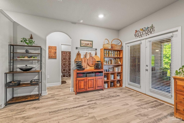 8056 Stream Ridge Rd, Pensacola, FL 32526 - home office with light wood-style flooring, french doors, arched walkways, baseboards, and a textured ceiling