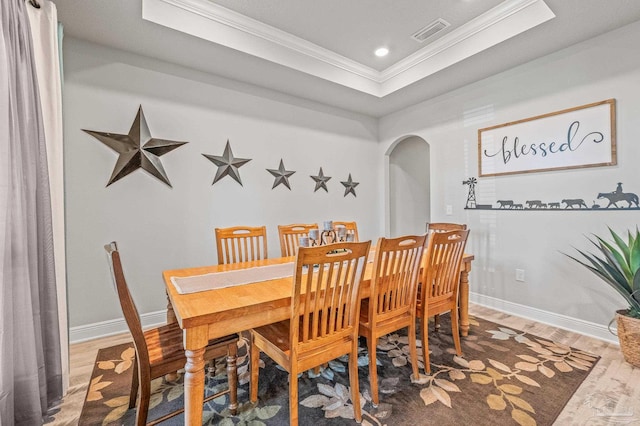 8056 Stream Ridge Rd, Pensacola, FL 32526 - dining area with arched walkways, ornamental molding, a tray ceiling, wood finished floors, and recessed lighting