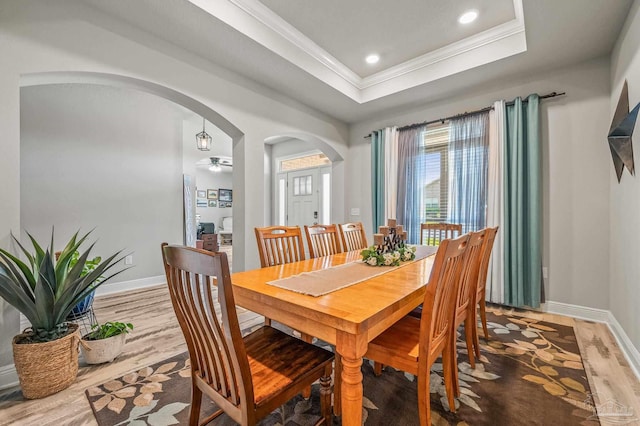 8056 Stream Ridge Rd, Pensacola, FL 32526 - dining room with arched walkways, a raised ceiling, wood finished floors, crown molding, and baseboards