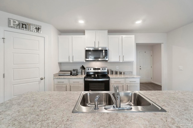 6173 Native Dancer Way, Pensacola, FL 32526 - kitchen with appliances with stainless steel finishes, white cabinetry, light countertops, wood finished floors, and recessed lighting
