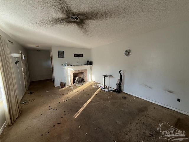 unfurnished living room with a brick fireplace and a textured ceiling