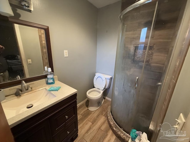 bathroom with vanity, an enclosed shower, wood-type flooring, and toilet