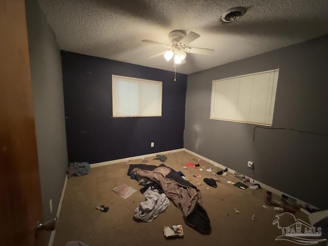 unfurnished bedroom with ceiling fan and a textured ceiling