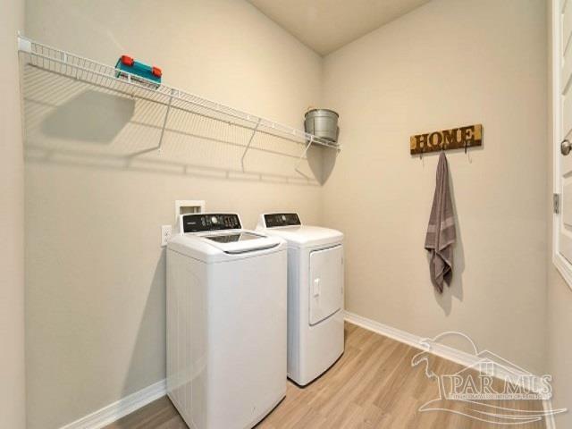 washroom with light hardwood / wood-style floors and washer and clothes dryer