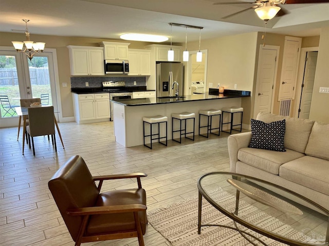 1792 Galvez Dr, Gulf Breeze, FL 32563 - living room featuring sink, ceiling fan with notable chandelier, and light hardwood / wood-style flooring