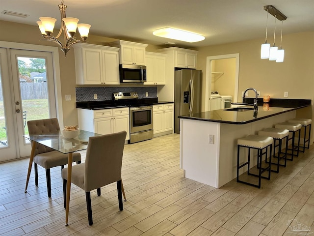 1792 Galvez Dr, Gulf Breeze, FL 32563 - kitchen with decorative light fixtures, white cabinets, and appliances with stainless steel finishes
