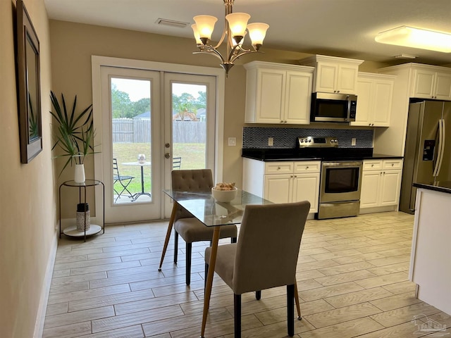 1792 Galvez Dr, Gulf Breeze, FL 32563 - kitchen with backsplash, stainless steel appliances, hanging light fixtures, and white cabinets