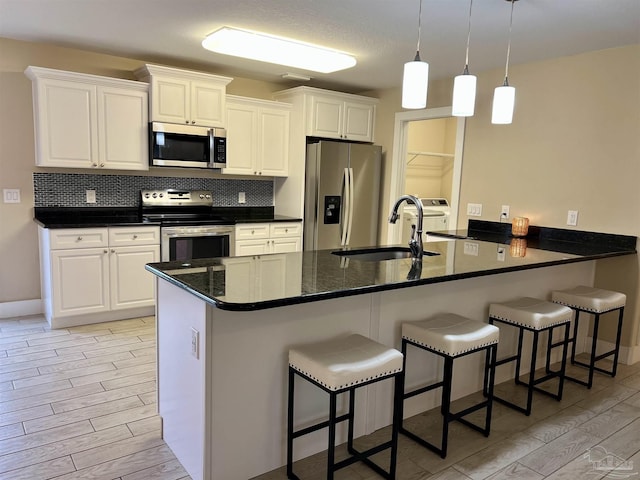 1792 Galvez Dr, Gulf Breeze, FL 32563 - kitchen with sink, white cabinetry, kitchen peninsula, stainless steel appliances, and decorative backsplash