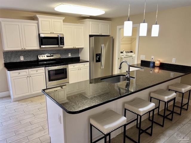 1792 Galvez Dr, Gulf Breeze, FL 32563 - kitchen featuring appliances with stainless steel finishes, sink, white cabinets, and kitchen peninsula
