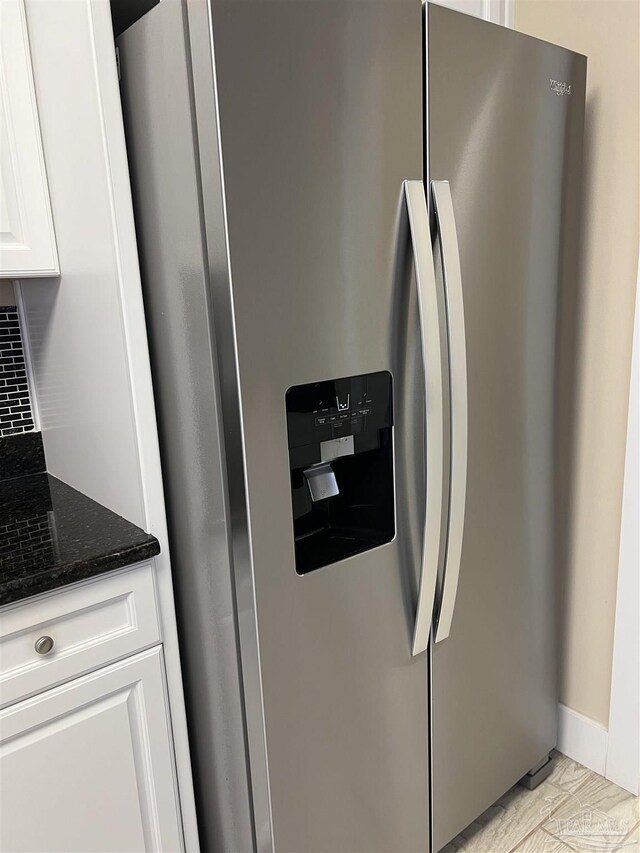 1792 Galvez Dr, Gulf Breeze, FL 32563 - details with dark stone countertops, backsplash, white cabinets, and stainless steel refrigerator with ice dispenser