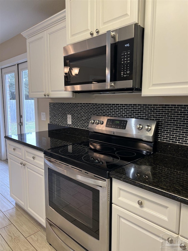 1792 Galvez Dr, Gulf Breeze, FL 32563 - kitchen with white cabinetry, appliances with stainless steel finishes, tasteful backsplash, and dark stone countertops
