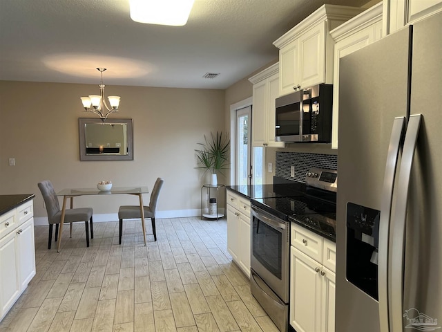 1792 Galvez Dr, Gulf Breeze, FL 32563 - kitchen featuring appliances with stainless steel finishes, light hardwood / wood-style floors, hanging light fixtures, and white cabinets