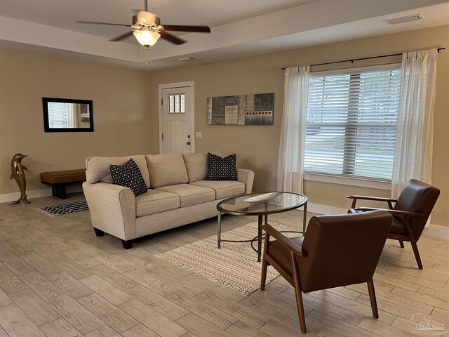 1792 Galvez Dr, Gulf Breeze, FL 32563 - living room with a tray ceiling, plenty of natural light, ceiling fan, and light wood-type flooring