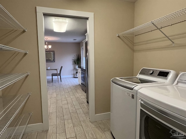 1792 Galvez Dr, Gulf Breeze, FL 32563 - laundry room featuring separate washer and dryer and an inviting chandelier