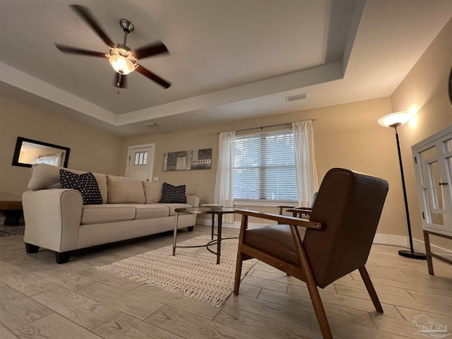 1792 Galvez Dr, Gulf Breeze, FL 32563 - living room with a tray ceiling, light hardwood / wood-style floors, and ceiling fan