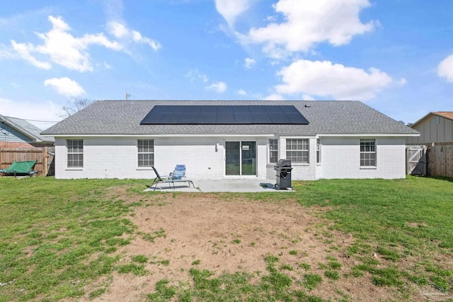 back of house featuring brick siding, a lawn, a patio area, and a fenced backyard