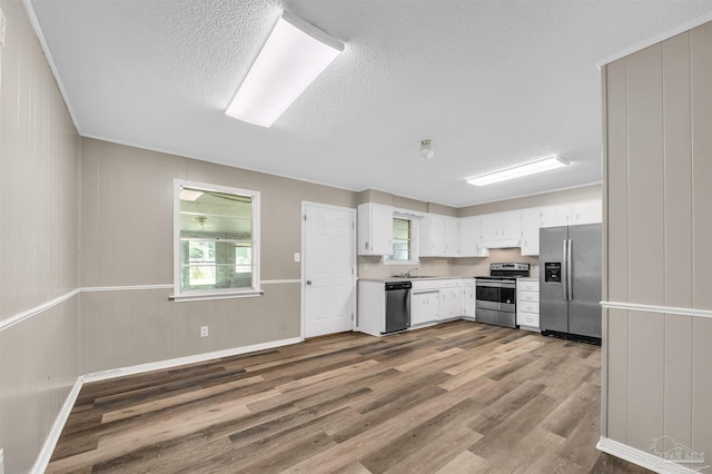 2382 Ryale Rd, Cantonment, FL 32533 - kitchen featuring appliances with stainless steel finishes, wood finished floors, a textured ceiling, healthy amount of natural light, and white cabinets