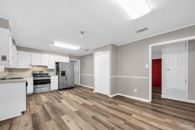 2382 Ryale Rd, Cantonment, FL 32533 - kitchen with stainless steel appliances, a sink, light wood finished floors, light countertops, and crown molding