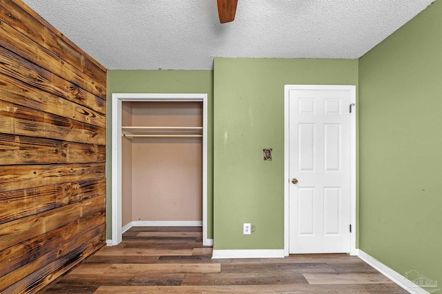 2382 Ryale Rd, Cantonment, FL 32533 - unfurnished bedroom with a closet, wood finished floors, baseboards, a textured ceiling, and ceiling fan