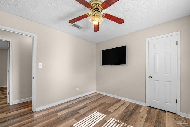2382 Ryale Rd, Cantonment, FL 32533 - unfurnished bedroom featuring wood finished floors, baseboards, a textured ceiling, and a ceiling fan