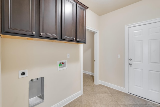 laundry room with electric dryer hookup, cabinets, light tile patterned floors, and hookup for a washing machine