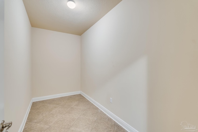 empty room with lofted ceiling and a textured ceiling