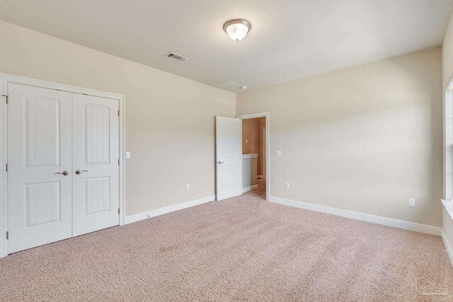 unfurnished bedroom featuring a closet and carpet floors