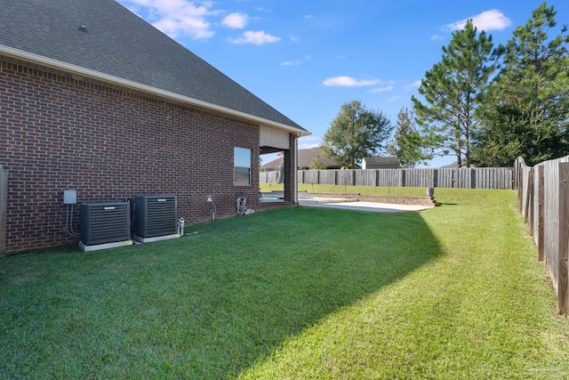 view of yard with central air condition unit and a patio