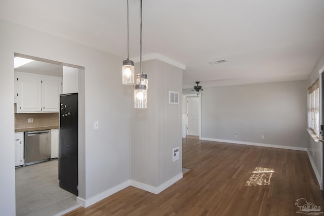 unfurnished dining area with a ceiling fan, light wood-style floors, visible vents, and baseboards