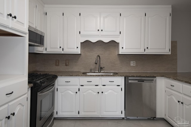 kitchen with white cabinetry, decorative backsplash, appliances with stainless steel finishes, and a sink