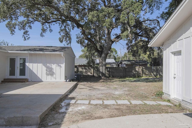 view of yard featuring french doors, a patio area, and fence