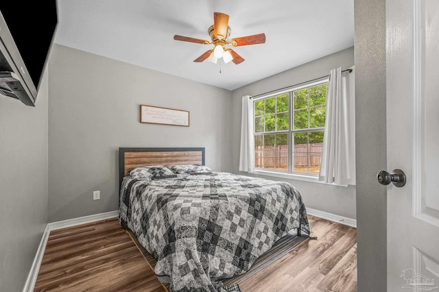 bedroom featuring baseboards, a ceiling fan, and wood finished floors