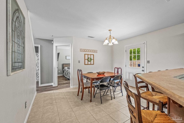 dining space featuring an inviting chandelier, light tile patterned floors, baseboards, and visible vents