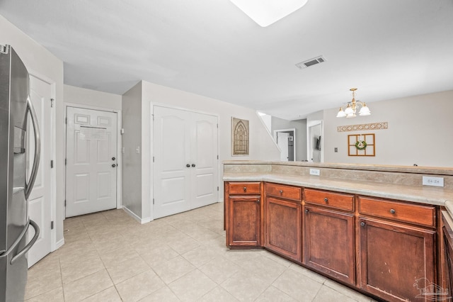 kitchen featuring visible vents, light countertops, stainless steel fridge with ice dispenser, light tile patterned floors, and a chandelier