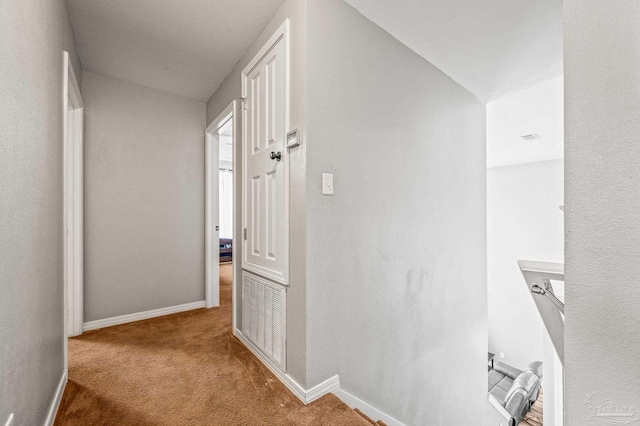 corridor featuring carpet floors and baseboards