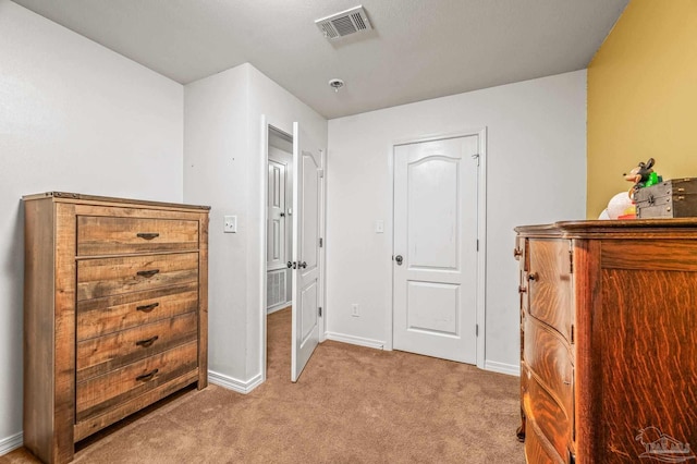 bedroom with visible vents, baseboards, and light carpet