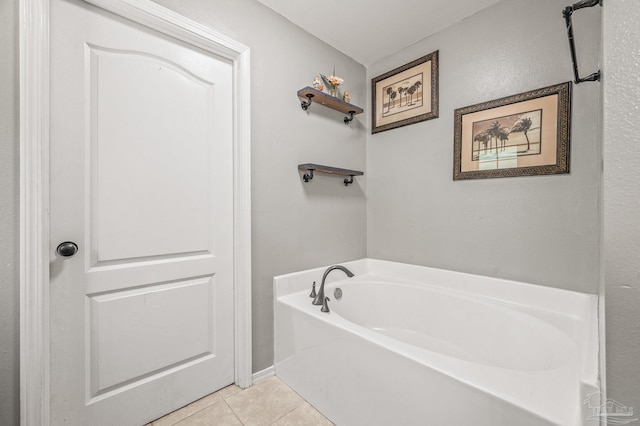 bathroom with a garden tub and tile patterned flooring