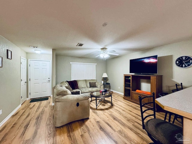 living room with light hardwood / wood-style floors and ceiling fan