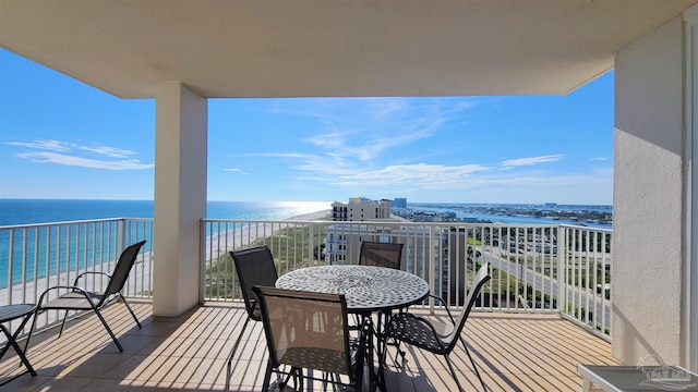 balcony featuring a view of the beach and a water view