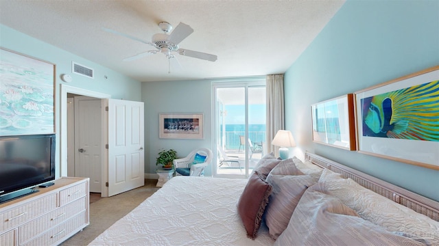 bedroom with a textured ceiling, light carpet, access to exterior, and ceiling fan