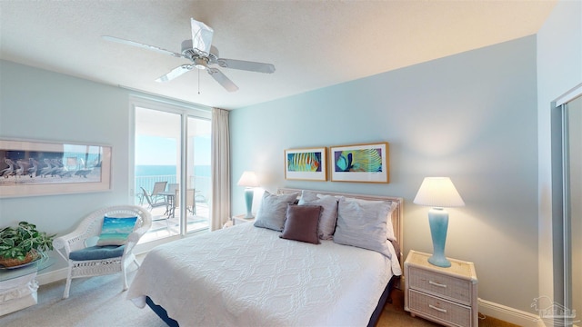 bedroom with a water view, ceiling fan, access to outside, and carpet floors