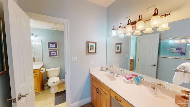 bathroom with toilet, vanity, and tile patterned floors