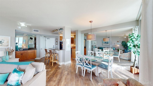 dining space featuring hardwood / wood-style floors, sink, and ceiling fan